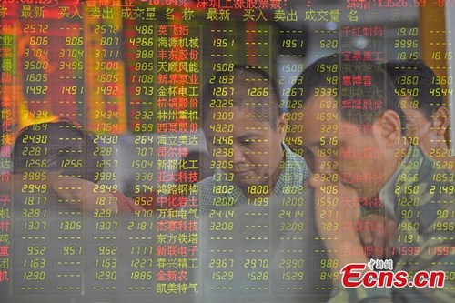 Investors look through stock information at a trading hall in a securities firm in Haikou, capital of northeast China's Hainan Province, June 29, 2015. (CNS photo/Luo Yunfei)