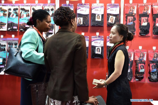 A Chinese exhibitor introduces wigs to visitors during the China Trade Week held at Kenyatta International Conference Centre in Nairobi, Kenya, July 1, 2015. Kenya kicked off a three-day exhibition in Nairobi on Wednesday to woo Chinese business community to invest in diverse sectors of the economy. (Xinhua/Sun Ruibo)