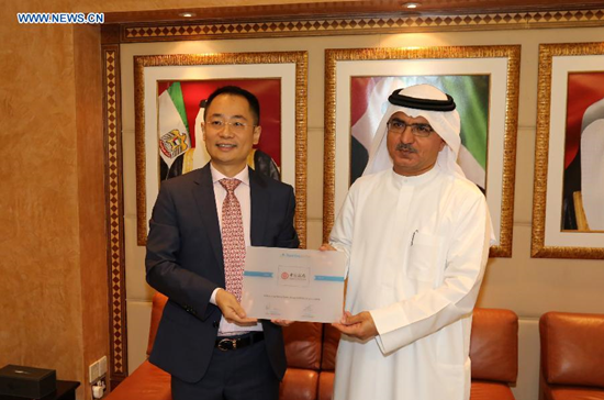 General manager of the Abu Dhabi branch of the Bank of China (BOC) Tian Jun (L) and Chairman of Nasdaq Dubai Abdul Wahed Al Fahim display a license in Dubai, the United Arab Emirates (UAE), on July 1, 2015. (Photo: Xinhua/Li Zhen)