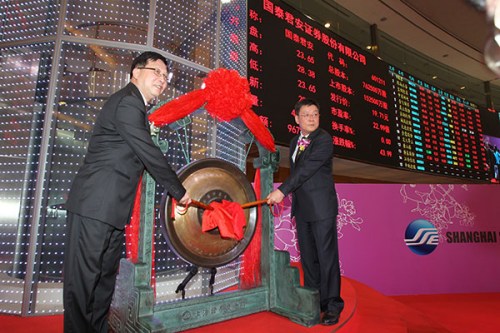 Kong Qingwei (left), Party chief of the Shanghai Financial Service Office, and Yang Dehong, chairman of Guotai Junan Securities Co Ltd, ring the gong to open trading of shares in the company at the Shanghai Stock Exchange on June 26. (Photo/China Daily)