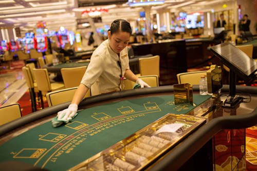 An employee cleans a blackjack table inside the Galaxy Macao Phase 2 casino. (Photo/China Daily)