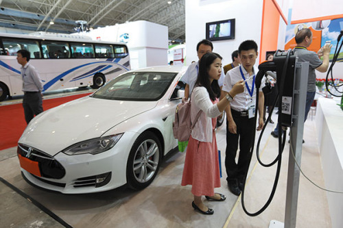 Visitors at a recent new-energy vehicle expo in Beijing examine charging posts. The city is suffering from a shortage of the facilities. Photo/China Daily