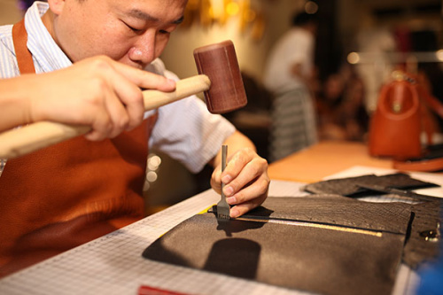 A craftsman works on a product at Larrot.Ray's first customer experience store in Beijing, July 7, 2015. (Photo /chinadaily.com.cn)