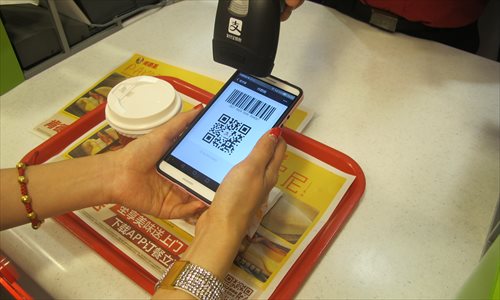 A customer pays with her Alipay app on smartphone in a KFC store in Xidan, Beijing. (Photo: GT/Yang Jing)
