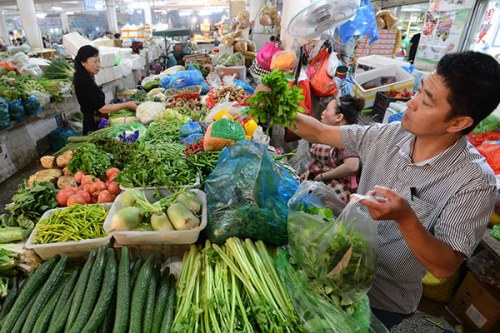 Residents in Fuyang, Anhui province, buy vegetables at a market on Thursday. In the first half of the year, The Consumer Price Index rose 1.3 percent from a year earlier, much lower than the annual target of 3 percent. (Photo/China Daily)