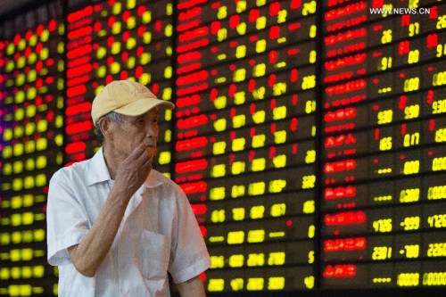 An investor follows information at a stock trading hall in Nanjing, capital city east China's Jiangsu Province, July 15, 2015. (Photo: Xinhua/Su Yang)