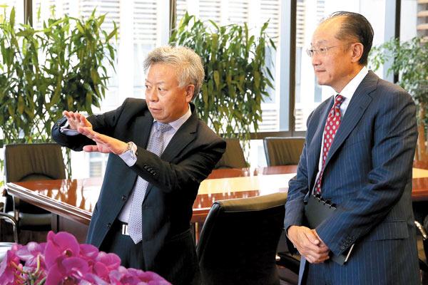 Jin Liqun (left), secretary-general of the Asian Infrastructure Investment Bank's Multilateral Interim Secretariat and China's nominee for president of the bank, holds talks with World Bank President Jim Yong Kim on Thursday. Wu Zhiyi / China Daily