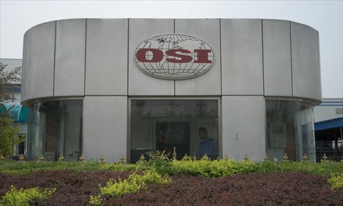 A security guard plays with his smartphone at the OSI factory in Dachang county in Hebei Province on Wednesday. (Photo: GT/Chen Qingqing)