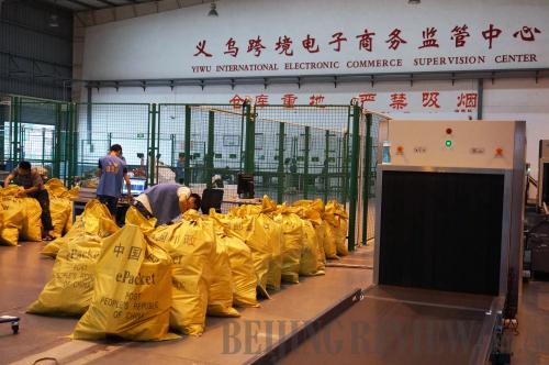 Workers clear up packages of small commodities ready for export customs clearance at Yiwu Cross-Border E-commerce Supervision Center in Yiwu, Zhejiang Province, on June 3 (XINHUA) 