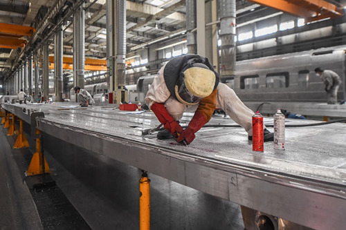 Workers polish the frames of railway vehicles at the Changchun Railway Vehicles Co in Jilin province. (Photo/China Daily)