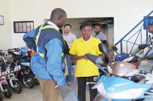 A saleswoman chats with a customer about e-bikes at the Chee Tah store in Nairobi, Kenya. (Photo/China Daily)