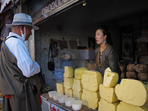 Dekyi Drolma (right) meets with a customer at her butter shop in Lhasa, Tibet autonomous region. (Palden Nyima/China Daily)