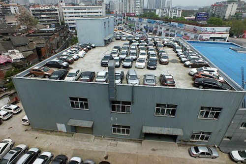 Carmakers urged to work closely with dealers An auto showroom in Yichang, Hubei province, uses its roof as a parking lot to store its unsold cars. Car dealers in China say sales will be sluggish for the second half this year. Photo/China Daily