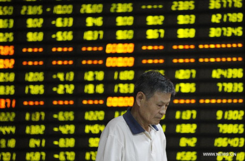 A man pays attention to stock market quotation at a business lobby of a security company in Huaibei, east China's Anhui Province, July 27, 2015. The Shanghai Composite Index dived more than 8 percent Monday, the biggest daily drop since 2007. (Xinhua/Xie Zhengyi)