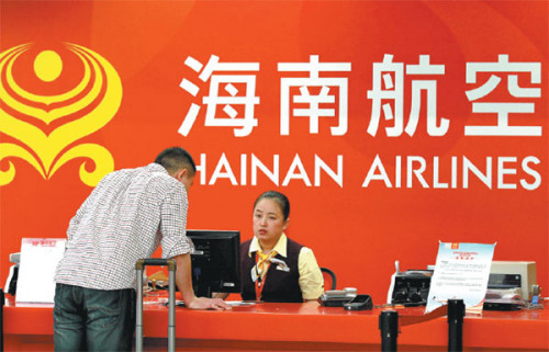 Hainan Airlines employee answers passenger queries at a service counter in Haikou, Hainan province.(Shi Yan/China Daily)