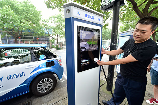A driver swipes a card to pay for charging his electric car. Standards are being revised for the sector and are expected to cover charging posts and electric vehicle sockets, enabling new-energy cars from different marques to share charging posts. (Li Zhong / For China Daily)