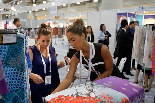 Two exhibitors display their company's textile products during the international textile and apparel sourcing show at the Jacob K. Javits Convention Center in New York. (Photo/Xinhua)