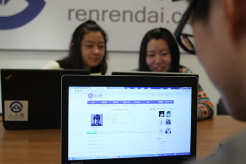 Customers make inquries at a Renrendai Co Ltd outlet in Beijing. The company, a major P2P Internet lending platform, saw transactions surge by 186 percent in the first six months of this year. (Zhu Xingxin/China Daily)