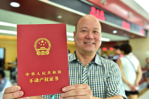 He Xianmin, a Yiwu, Zhejiang province resident with the revamped real estate right certificate. The certificate information will be included in the proposed national unified information platform, that will be established by 2017, paving the way for the possible levy of property taxes. (Lyu Bin/China Daily)
