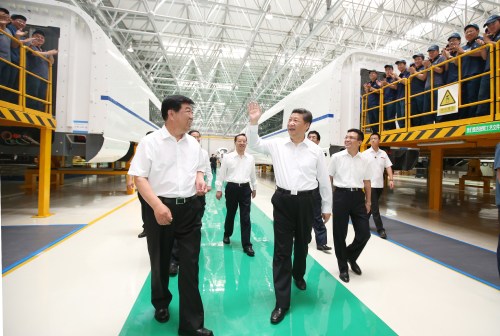 Chinese President Xi Jinping (center) talks with workers during his visit to Changchun Railway Vehicles Co. Ltd. in Changchun, capital of northeast China's Jilin Province, on July 17 (XINHUA)