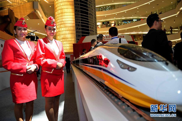 Two Miss Etiquettes stand beside a model of Chinese high-speed rail at the Chinese-backed high-speed rail expo in Jakarta, Indonesia on August 13, 2015. (Photo/Xinhua)