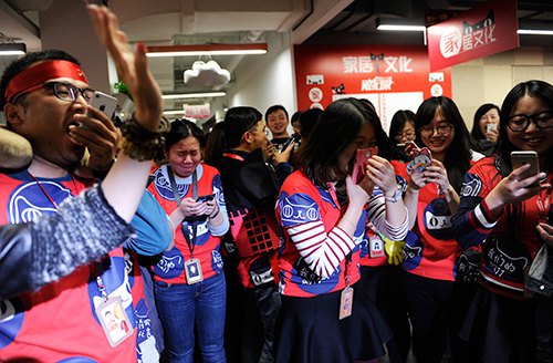 Employees of Tmall.com, a B2C platform operated by Alibaba Group, celebrate in the company's headquarters in Hangzhou, Zhejiang Province, after its turnover recorded an all-time high during the annual online shopping festival on November 11, 2014 (XINHUA) 