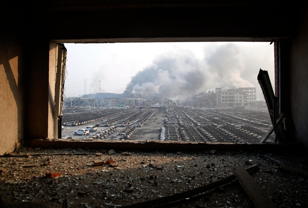 New cars are heavily damaged at a port next to the warehouse that exploded. (Dan Haihan/China Daily)