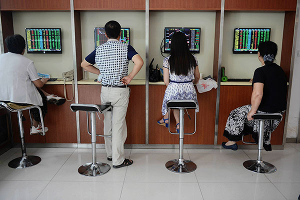 Retail investors check share prices at a brokerage in Qingdao, Shandong province, on Aug 18. The benchmark Shanghai Composite Index plunged by 6.15 percent to close at 3,748.16 points. (Yu Fangping / For China Daily)