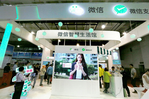 A display board showing Tencent Holdings Ltd's WeChat messaging and online payment services at an expo in Beijing. Its investment in the Canadian messaging firm Kik Interactive is part of efforts to tap the North American market.(Photo provided to China Daily)