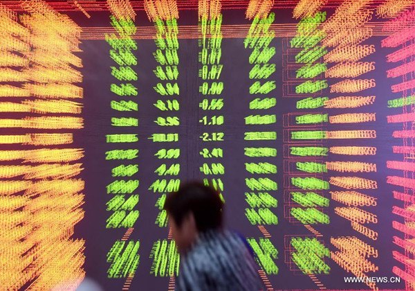 An investor looks through stock information at a trading hall of a securities firm in Luoyang, central China's Henan Province, Aug. 24, 2015. China stocks nosedived on Monday with the benchmark Shanghai Composite Index dropping 8.49 percent to close at 3209.91 points, the sharpest decline since Feb. 27, 2007. (Xinhua/Zhang Yixi) 