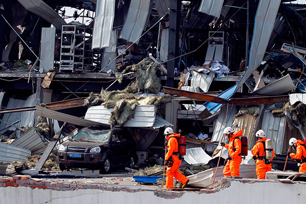 Rescuers at the Tianjin chemical explosion site. The tragic incident has reportedly demonstrated the danger China faces by not diversifying its insurance risks. (Zhu Xingxin / China Daily)