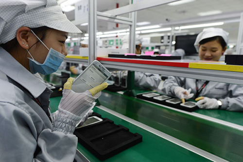 Workers check mobile phones at a production base of Lenovo Group Ltd in Wuhan, capital of Hubei province. (Zhou Chao/For China Daily)
