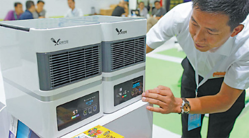 An exhibitor explains the functions of an air purifier at an exhibition in Beijing. Last year, 5.1 million air purifiers for home and office use were sold in China. (Zhu Xingxin/China Daily)