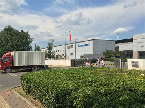 People pass the gate of Panasonic's battery plant in Beijing Thursday. (Photo: Chen Qingqing/GT)
