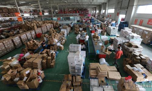 Workers pack commodities according to electronic orders in a Zhengzhou-based cross-border e-commerce supervision center on May 29 (XINHUA)