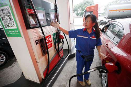 An attendant filling gasoline onto a car at a Sinopec gas station in Huaibei, Anhui province. For Sinopec, falling oil prices mean lower production costs for its downstream refining and petrochemical business. (Photo/China Daily)