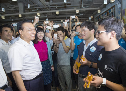 Chinese Premier Li Keqiang (L) attends the road show for a new innovative enterprise at a platform providing services to makers, or those who turn innovative ideas to products, in the high-tech zone of Dalian, northeast China's Liaoning Province, Sept. 9, 2015. Li had an inspection tour in Dalian on industrial upgrade as well as mass entrepreneurship and innovation during his stay for the Summer Davos forum here. (Photo: Xinhua/Wang Ye)