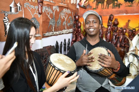 A visitor and an exhibitor play drum during the China-Arab States Expo in Yinchuan, capital of northwest China's Ningxia Hui Autonomous Region, Sept. 12, 2015. As the China-Arab States Expo concluded Sunday, a cooperative platform was formed to enhance the bilateral economic exchanges and other fields between China and Arab countries. (Photo: Xinhua/Li Ran) 