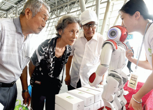 Visitors examine a robot designed to serve the elderly at an expo in Anhui province, on Aug 14. (Photo/Xinhua)