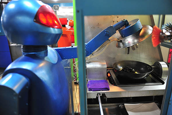 A robot stir-fries a dish at a restaurant in Harbin, capital of Heilongjiang province. (Photo provided to China Daily)