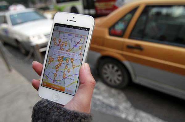 A customer checks his smartphone app that eases finding a taxi. (Photo/China Daily)