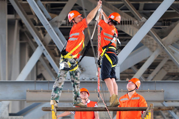 Workers reinforce a bridge on the Yangtze River in Jiujiang, Jiangxi province. (Photo/China Daily)