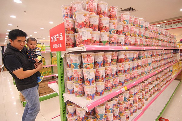 A man examines imported food products at a store of a cross-border e-commerce provider in Guangzhou, capital of Guangdong province. For foreign companies, which are keen to attract Chinese customers, Internet campaigns can have a positive impact on sales and brand awareness. (Photo/China Daily)