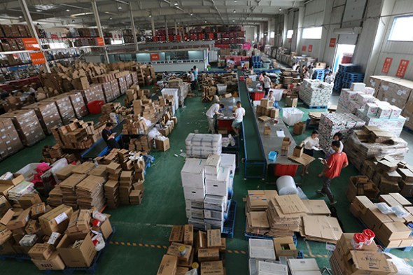 Workers packed the imported goods in Zhengzhou Cross-border E-commerce Center, Central China's Henan province, May 29, 2015. Zhengzhou is one of the pilot cities for import e-commerce in China. (Photo/Xinhua)