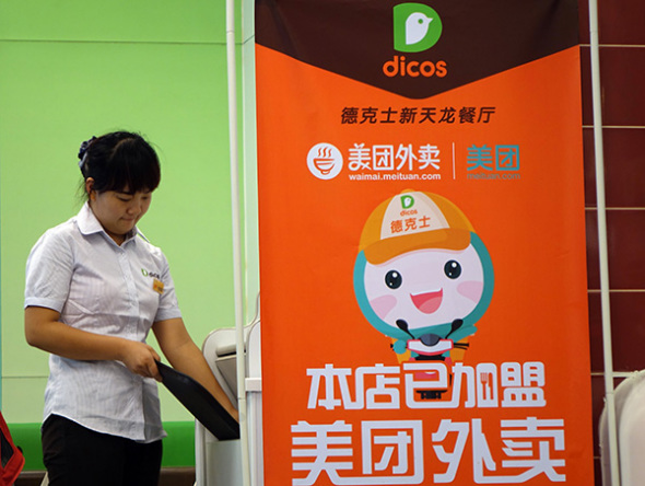 An employee at a Dicos outlet, a Western-style fast-food chain, in Zhengzhou, Henan province. The food chain has teamed up with Meituan, a group-buying service promoted by e-commerce giant Alibaba Group Holding Ltd. Uber ups its ante in China. (Photo/China Daily)