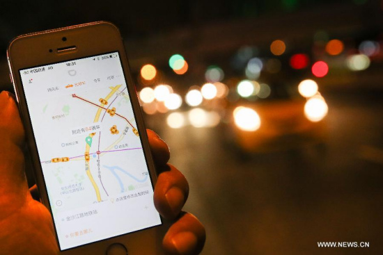 A citizen books taxi on a street in Shanghai, east China, Oct. 8, 2015. Shanghai's transport authority granted China's first license for running a ride-hailing platform to Didi Kuaidi, car service Uber's major rival in China, at a forum on Thursday. (Photo: Xinhua/Pei Xin)