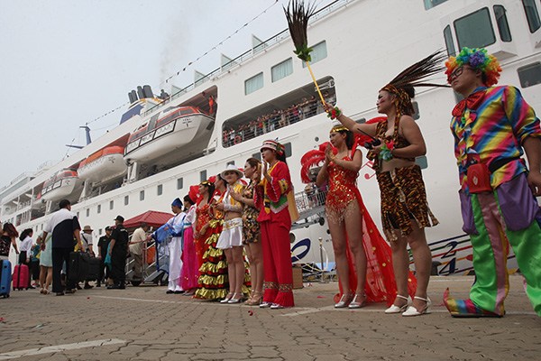 Performers welcome passengers aboard for a cruise in Yantai, Shandong province. The China Cruise and Yacht Industry Association said it expects about 1 million Chinese tourists to take cruises this year, compared with 861,700 passengers last year. (Photo/China Daily)