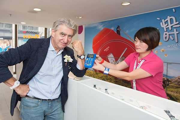 Nick Hayek, CEO of Swatch Group, demonstrates a new wrist watch that enables payment via China UnionPay's system at the launch ceremony in Shanghai. (Photo/China Daily)