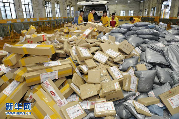 Staff members at an express delivery company in Guangzhou, south China's Guangdong province, are busy arranging the packages on Monday, November 11, 2013. (Photo: Xinhua/Liang Xu)