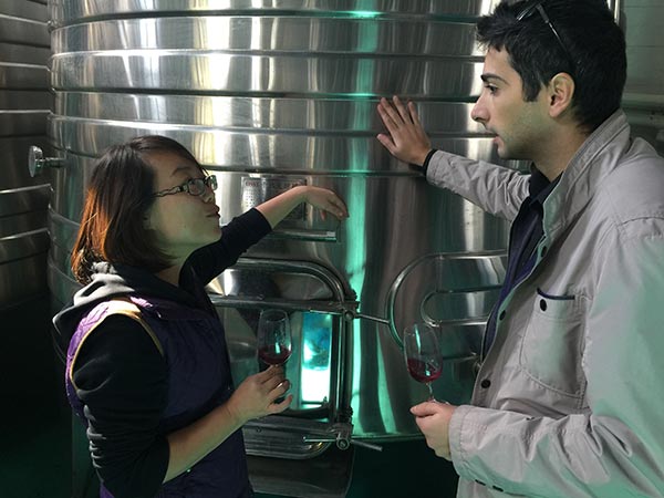 Competitor Alessio Fortunato (right) from Italy talks about blending with Zhang Jing, winemaker at Helan Qingxue, where Fortunato's entry will be aging until the judging in 2017. (Photo by Mike Peters/China Daily)